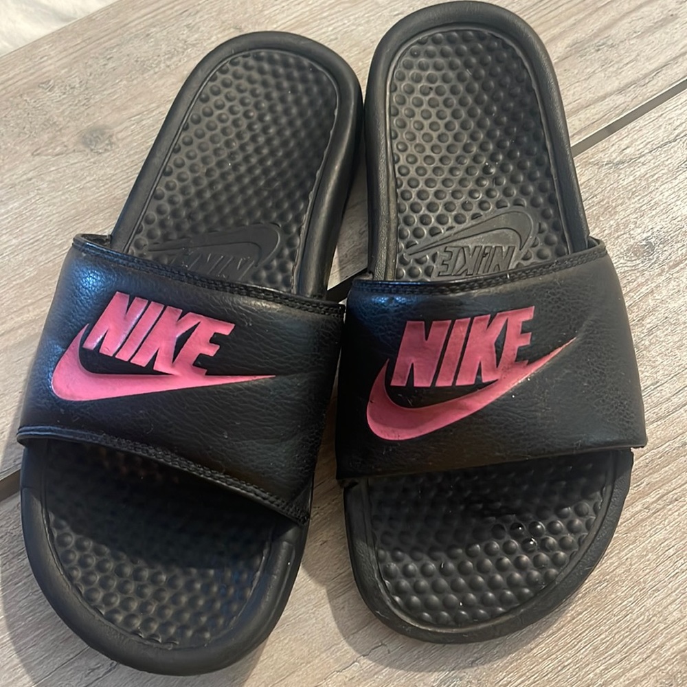 Pink and black nike slides.